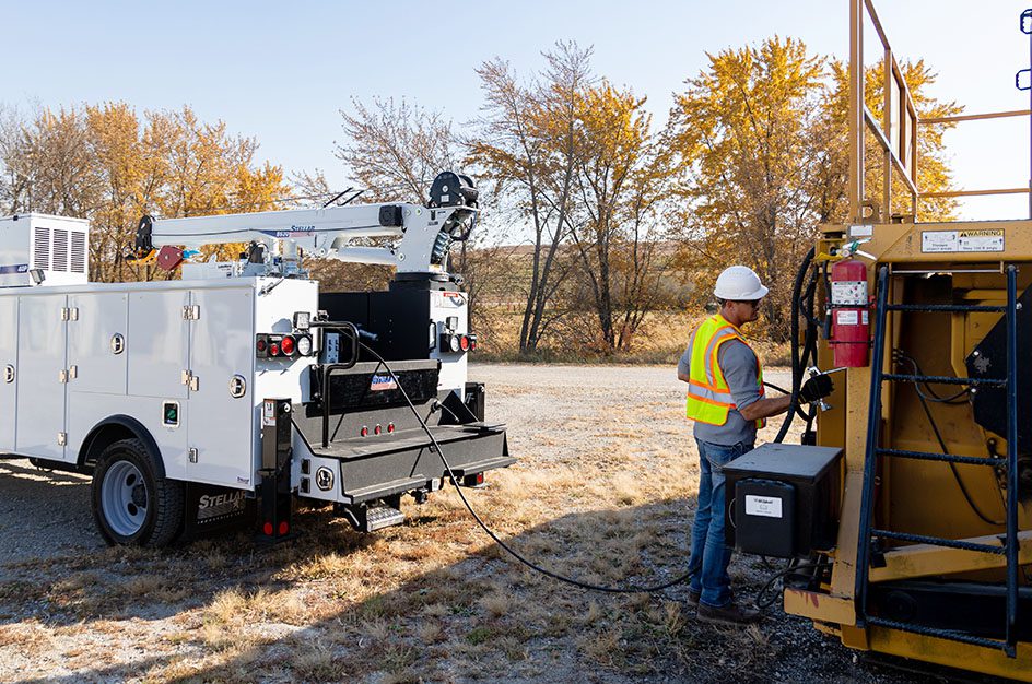 Man attaching cable from Stellar mech truck to other equipment