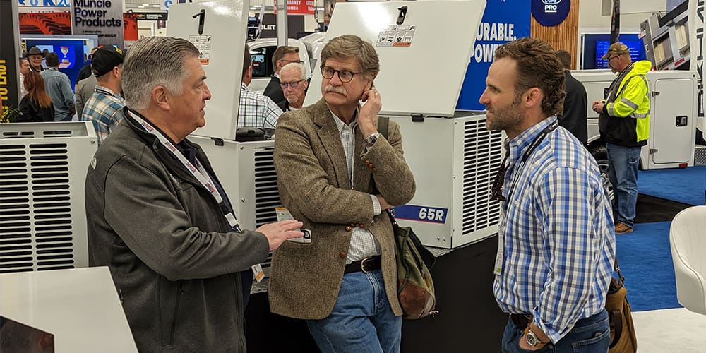 Stellar President Dave Z talking to two others in front of Stellar Air Compressors